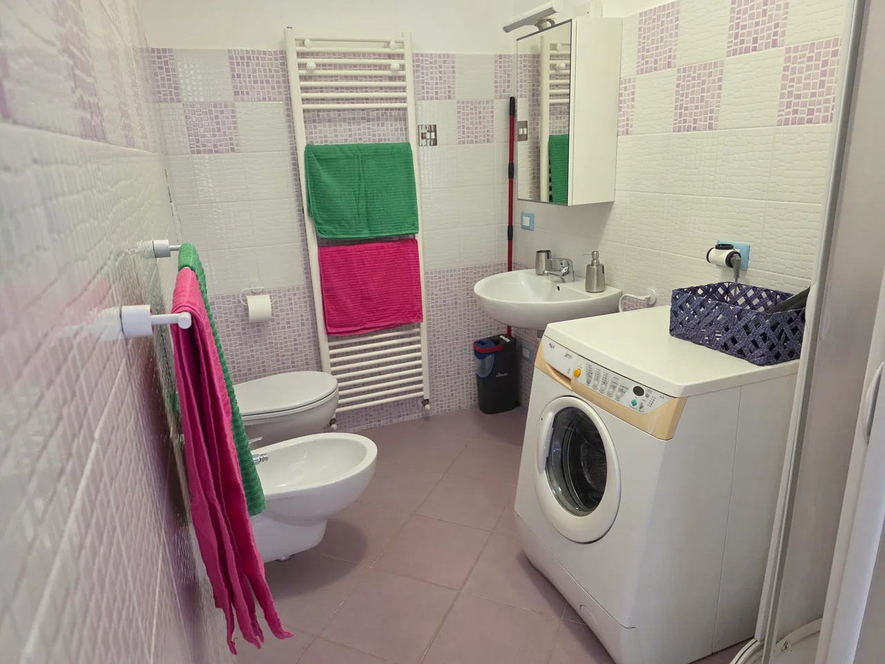 Il bagno dell’appartamento, con lavabo, sanitari e lavatrice.